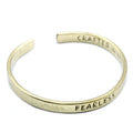 Gold bracelet with 'FEARLESS' engraved on a white background