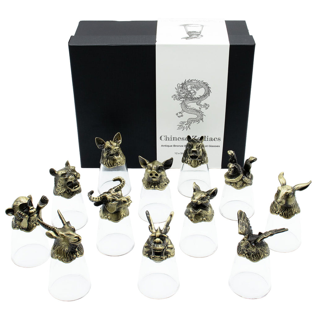 Set of twelve bronze animal head sculptures on clear stands with a branded box in the background.