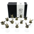 Set of twelve bronze animal head sculptures on clear stands with a branded box in the background.
